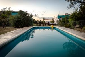 a swimming pool with blue water in a yard at La Obra in Tandil