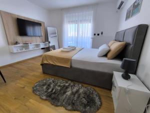 a bedroom with a large bed and a television at Apartman Vanja in Doboj