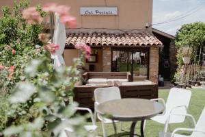 a patio with a table and chairs and a building at Cal Portalé - Casa de Pagès in Claverol