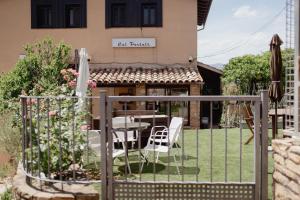a patio with a table and chairs in front of a building at Cal Portalé - Casa de Pagès in Claverol