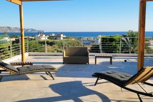 a patio with chairs and a view of the ocean at Crete Apart House in Ayía Marína