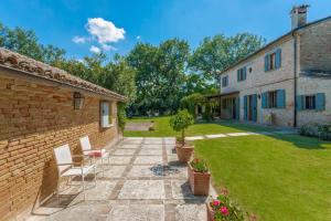 a patio with two chairs and a building at Villa Deda 12&2 by Marche Holiday Villas in Saltara