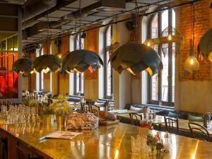 ein Restaurant mit einer langen Bar mit Tischen und Stühlen in der Unterkunft 25hours Hotel Altes Hafenamt in Hamburg