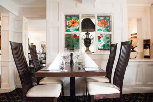 una sala da pranzo con tavolo, sedie e vetrate istoriate di The Treebridge Hotel a Nunthorpe