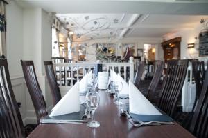 a wooden table with wine glasses and napkins on it at The Treebridge Hotel in Nunthorpe