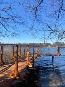 a wooden bridge over a body of water at Chatka nad jeziorem in Wólka