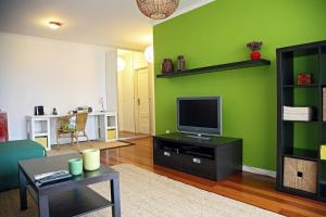 uma sala de estar com uma parede verde e uma televisão em Casa do Cavacas em Funchal