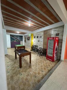 a room with a pool table and a coke machine at Pousada do mineiro in Cabo Frio