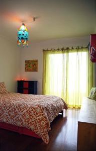 um quarto com uma cama e um lustre em Casa do Cavacas em Funchal