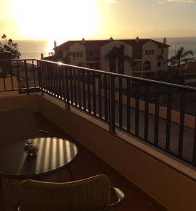 uma varanda com uma mesa e cadeiras e o oceano em Casa do Cavacas em Funchal
