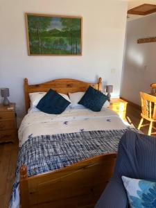 a bedroom with a wooden bed with blue pillows at The Granny Anne xe in Blain