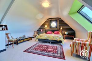 a bedroom with a bed in a attic at Les saudraies - unite familiale in Rieux +25 photos