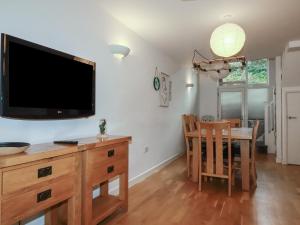 a living room with a television and a dining room table at Tregullan in Truro