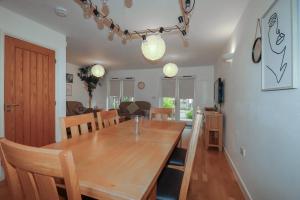 a dining room and kitchen with a wooden table at Tregullan in Truro