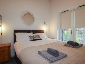a bedroom with a large bed with towels on it at Tregullan in Truro