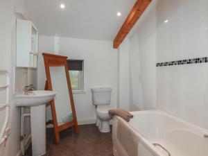 a bathroom with a tub and a toilet and a sink at Tregullan in Truro