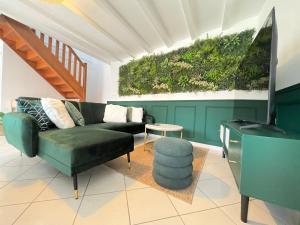 a living room with a green couch and a table at Villa Verde, magnifique gite à 10 min du Futuroscope in Saint-Léger