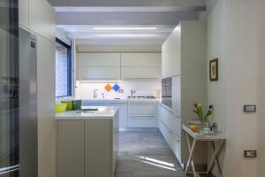 a white kitchen with white cabinets and a window at Casale Astralis 13 by Marche Holiday Villas in Saltara