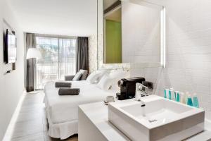 a white hotel room with a couch and a sink at Barceló Teguise Beach - Adults Only in Costa Teguise