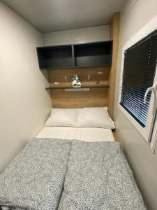 a small bedroom with a bed and a window at Green Hill Mobile Home in Ražanac