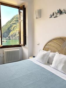 a bedroom with a large bed with a large window at Ca der Duse in Vernazza