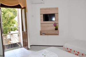 a room with a bed and a tv on a wall at Hotel Villa Real in Crato