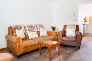 a living room with two chairs and a couch and a table at 3BR Cottage with Garden, Free Parking for 6 Guests in Alness