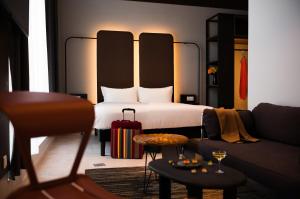 a hotel room with a bed and a couch at You Hotels Deauville - Handwritten Collection in Deauville