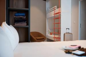 a bedroom with a bed and a walk in closet at You Hotels Deauville - Handwritten Collection in Deauville