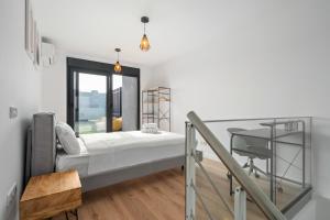 a room with a bed and a desk and a window at atico duplex con piscina y parking incluido ALQUILER TEMPORAL in San Sebastián de los Reyes