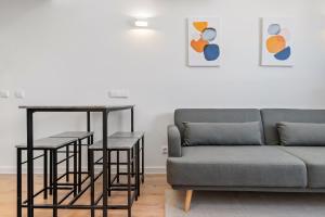 a living room with a couch and a table at atico duplex con piscina y parking incluido ALQUILER TEMPORAL in San Sebastián de los Reyes