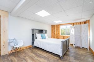 a bedroom with a bed and a chair in it at 5 Bedroom with Fire Pit, Patio & Large Yard in South Haven