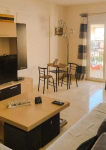 a living room with a tv and a table and chairs at Francesco's Apartment-Chalkidiki in Flogita