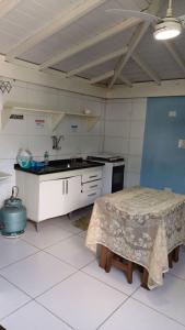 ウバトゥバにあるSuites Familia Otavianoのキッチン(テーブル、シンク付)