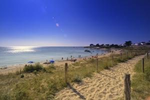 una spiaggia con ombrelloni e persone in acqua di Maison pour 8, 500m du port et des plages a Noirmoutier-en-l'lle