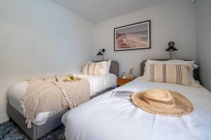 a bedroom with two beds with a hat on the bed at 3 Bedroom Luxury Waterside House in Hayle