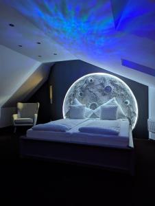 a bedroom with a bed with a moon mural on the wall at Himmel Suite in Schönau an der Brend