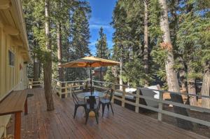 eine Terrasse mit Tisch und Stühlen und einem Sonnenschirm in der Unterkunft Peaceful Sunshine Chalet with Hot Tub in Big Bear Lake + 27 Fotos