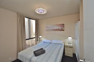 a bedroom with a bed and a clock on the wall at Riverview Holiday Apartment 28 - Kalbarri WA in Kalbarri