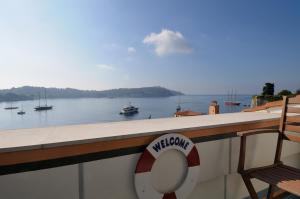 a balcony with a view of the water with boats at Welcome Hotel in Villefranche-sur-Mer