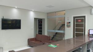 a waiting room with a chair and a television at Hotel Castanhal in Castanhal