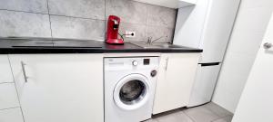 a red appliance sitting on top of a washing machine at Apartamento Puerta de Madrid 1 in Alcalá de Henares