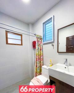 une salle de bain avec un lavabo et un rideau de douche dans l'établissement Charming 1-Bedroom Home Steps from Saturday Market, à Chiang Mai