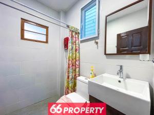 une salle de bain avec un lavabo, des toilettes et un miroir dans l'établissement Charming 1-Bedroom Home Steps from Saturday Market, à Chiang Mai