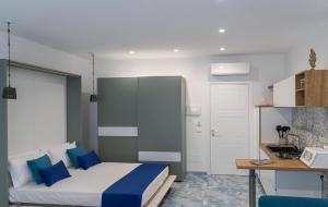 - une chambre avec un lit doté d'oreillers bleus et d'un bureau dans l'établissement Ercolano Deluxe Bed and Breakfast, à Ercolano