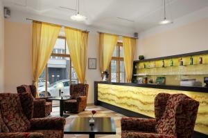 a restaurant with chairs and a bar with yellow curtains at EA Embassy Prague Hotel in Prague