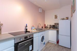 a kitchen with a washer and dryer and a refrigerator at Stravaig in Innerleithen