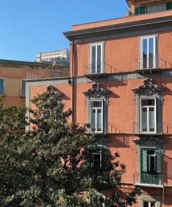un edificio con dos ventanas y un árbol delante de él en Deluxe Apartments in via Toledo, en Nápoles