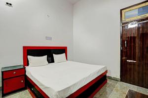 a bedroom with a bed with a red headboard and a window at Hotel O THE KING HEAVEN in Bhongaon +23 photos
