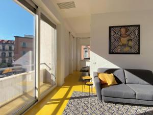 Una sala de estar con un sofá y una ventana grande. en Deluxe Apartments in via Toledo, en Nápoles